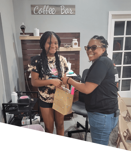 Two women are holding a bag of coffee.