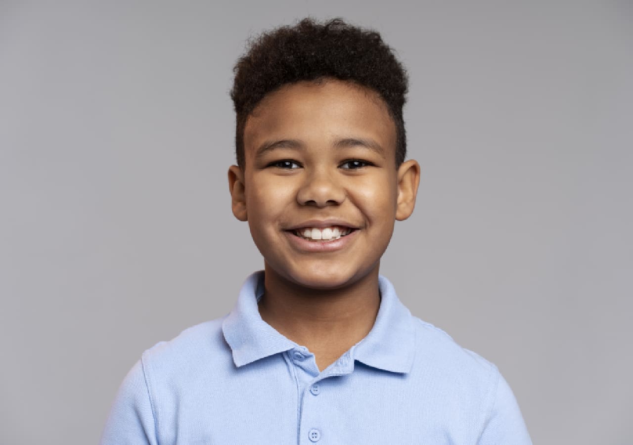 A young boy with a blue shirt and black hair.